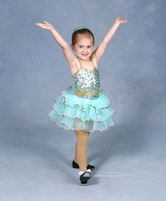 Dancer in a teal tutu with arms raised