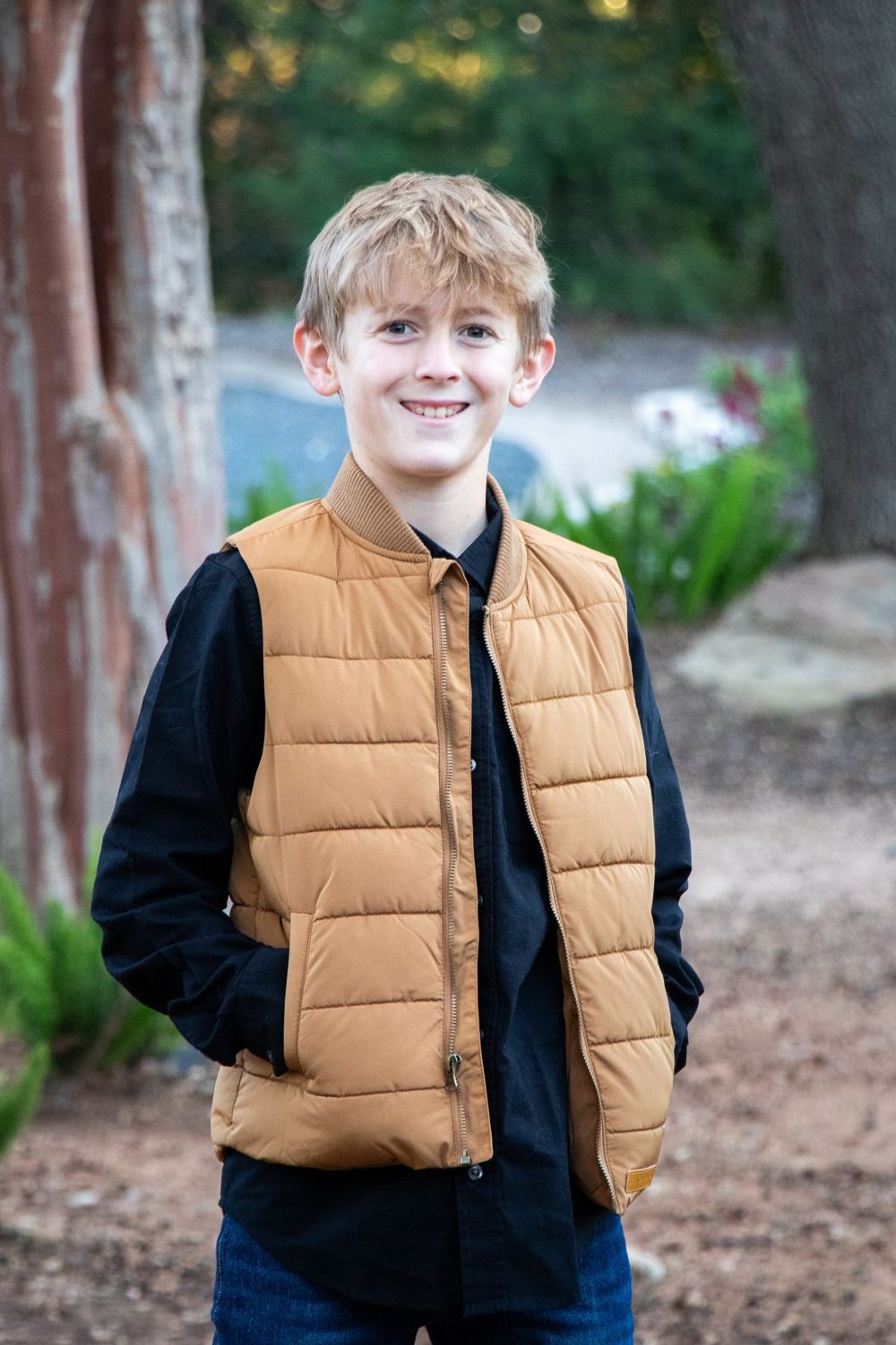 Portrait of a smiling boy in a tan vest